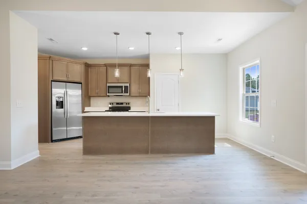 a large kitchen with kitchen island a sink stainless steel appliances and cabinets