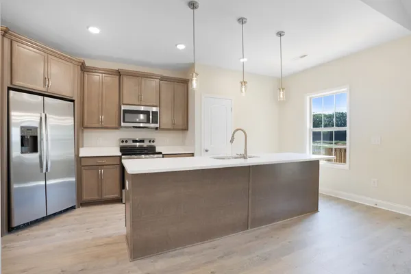 a kitchen with kitchen island a sink stainless steel appliances and window
