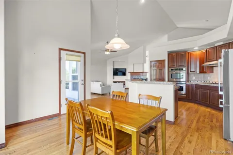 a dining room with furniture a chandelier and wooden floor