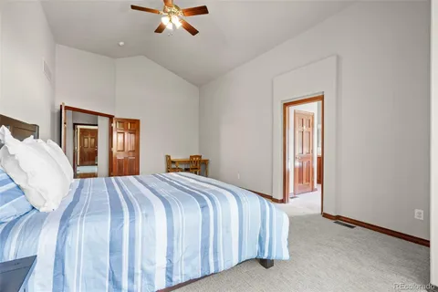 a bed sitting in a spacious bedroom next to a window