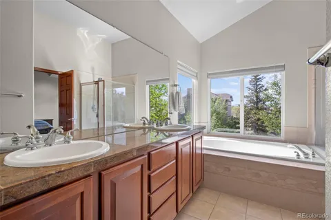 a bathroom with a granite countertop sink and a large mirror