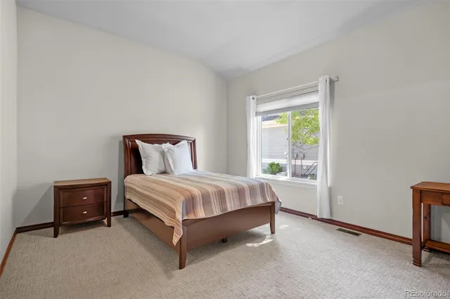 a bed sitting in a bedroom next to a window