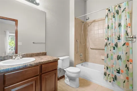 a bathroom with a granite countertop sink toilet a shower and a mirror