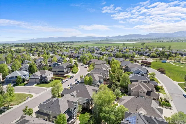 an aerial view of a city with lots of residential buildings and mountain view in back