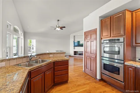 a kitchen with kitchen island granite countertop a sink stove and refrigerator