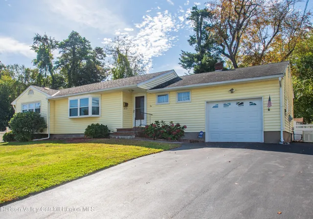a view of a house with a yard and garage