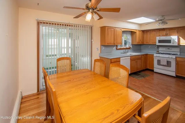 a large kitchen with stainless steel appliances granite countertop a sink a stove a dining table and chairs
