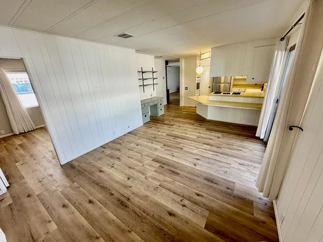 a room with a bed and a view of kitchen