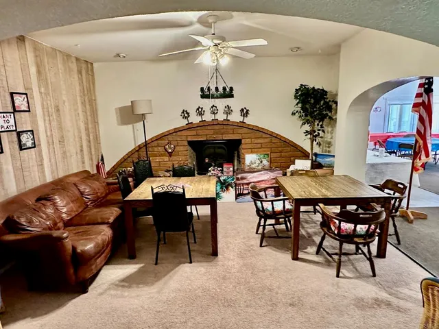 a living room with furniture a chandelier and a dining table