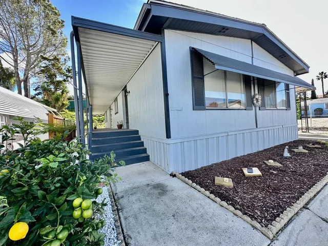 a view of a small house with wooden fence