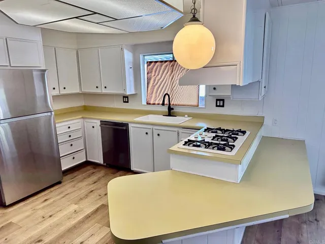 a kitchen with cabinets and stainless steel appliances