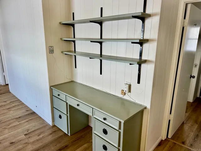 a kitchen with stainless steel appliances cabinets and a wooden floor