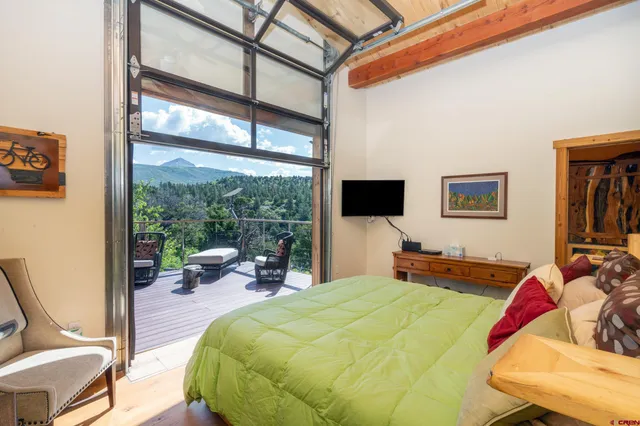 a living room with furniture a flat screen tv and a floor to ceiling window