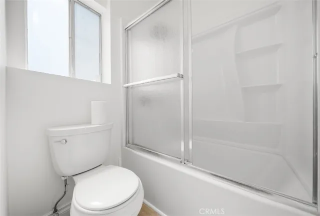 a white toilet sitting next to a bath tub