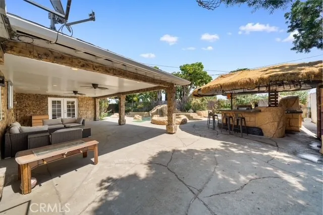 a view of a patio with dining table and chairs under an umbrella with a patio