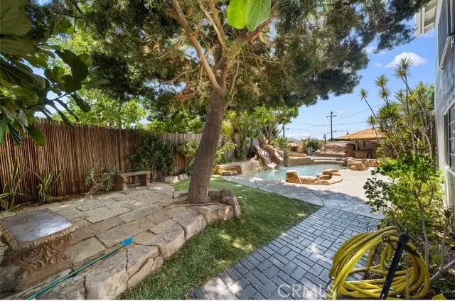 a backyard of a house with table and chairs under an umbrella