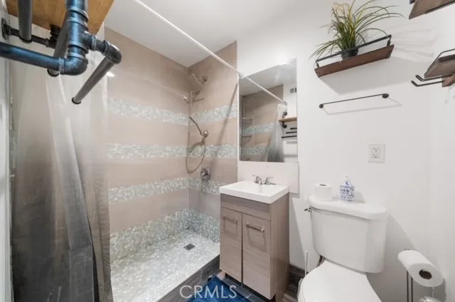 a bathroom with a sink a toilet and shower