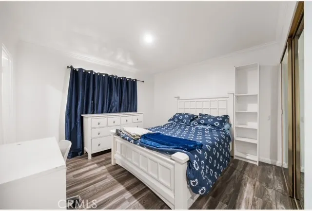 a bed sitting in a bedroom next to a window and dresser