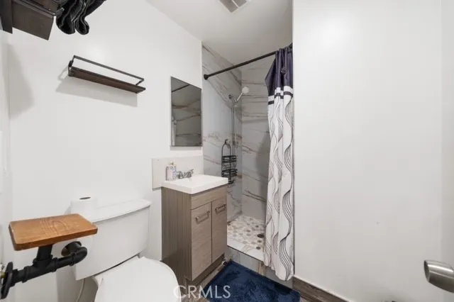 a bathroom with a granite countertop sink mirror vanity and toilet