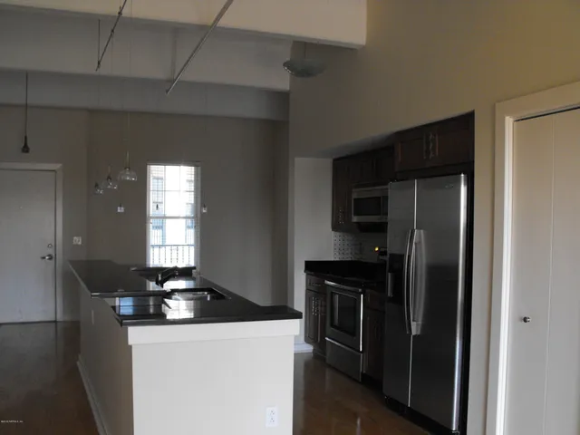 a view of a hallway with wooden floor and a living room
