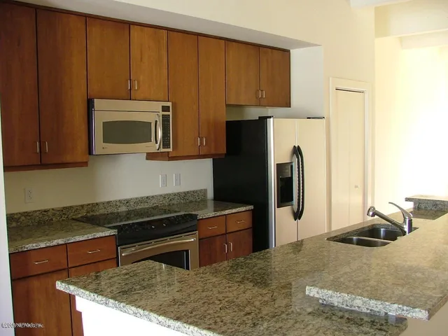 a kitchen with stainless steel appliances a stove microwave and sink