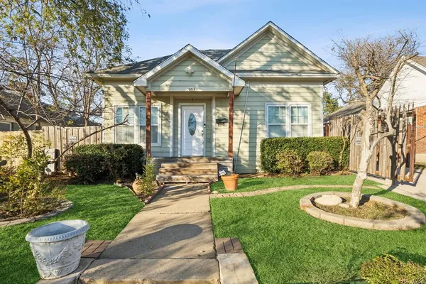 a front view of a house with a yard and fountain