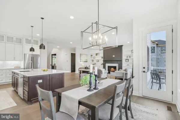 a view of a dining room and livingroom with furniture wooden floor a chandelier