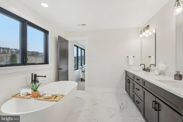a spacious bathroom with a granite countertop sink and a mirror