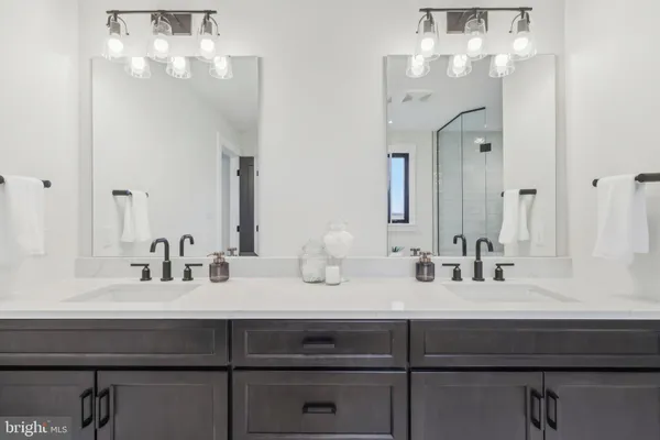 a bathroom with double vanity sinks a vanity and a mirror
