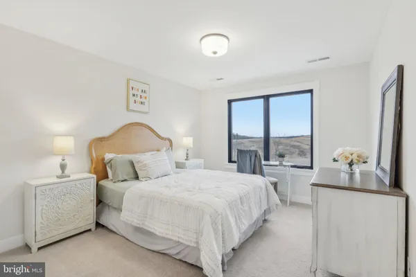 a bedroom with a bed and a large window
