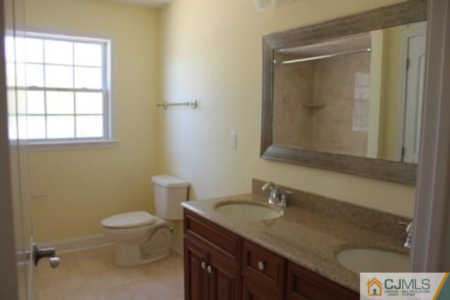4 Herron Road Edison, NJ 08820 - Photo 18 of 25 a bathroom with a granite countertop sink a toilet and a mirror