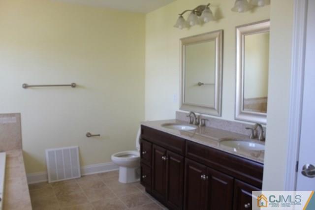 4 Herron Road Edison, NJ 08820 - Photo 19 of 25 a bathroom with a granite countertop sink a toilet and a mirror