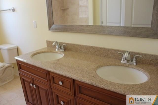 4 Herron Road Edison, NJ 08820 - Photo 22 of 25 a bathroom with a granite countertop sink and a mirror