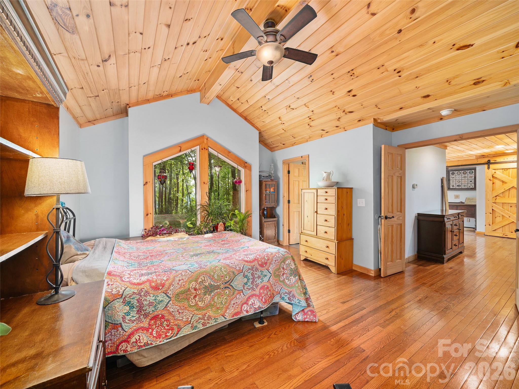 228 Continental Divide Road Spruce Pine, NC 28777 - Photo 15 of 48 a bedroom with a large bed and a chandelier