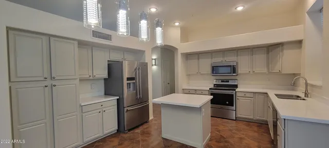a kitchen with stainless steel appliances a refrigerator sink and stove