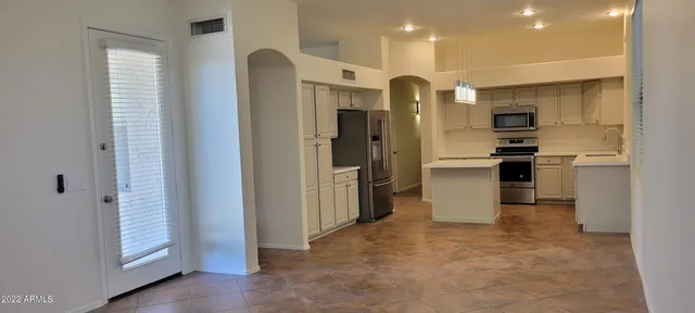 a kitchen with stainless steel appliances granite countertop a refrigerator and a sink