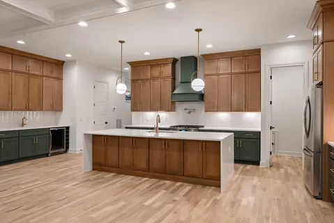 a kitchen with stainless steel appliances granite countertop a sink a stove and a refrigerator