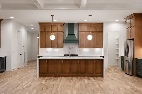 a kitchen with stainless steel appliances granite countertop a refrigerator a sink dishwasher a stove and a refrigerator