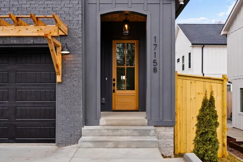 a view of a hallway with wooden floor and a bathroom