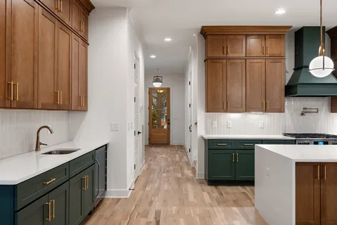 a view of an empty room with a kitchen and a window