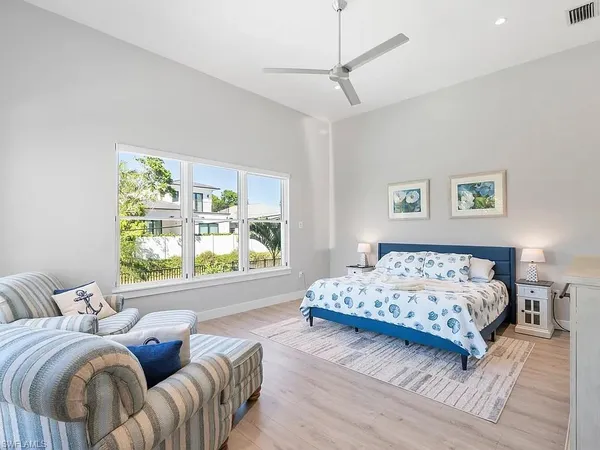a bedroom with a bed and a large window