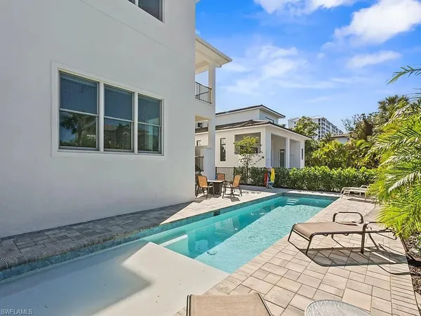 a view of a house with backyard sitting area and garden