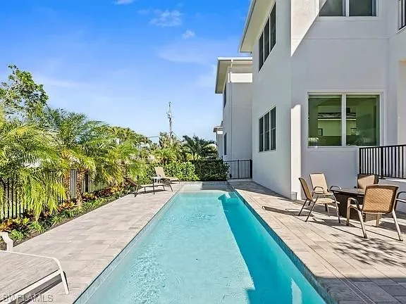 a view of house with swimming pool outdoor seating