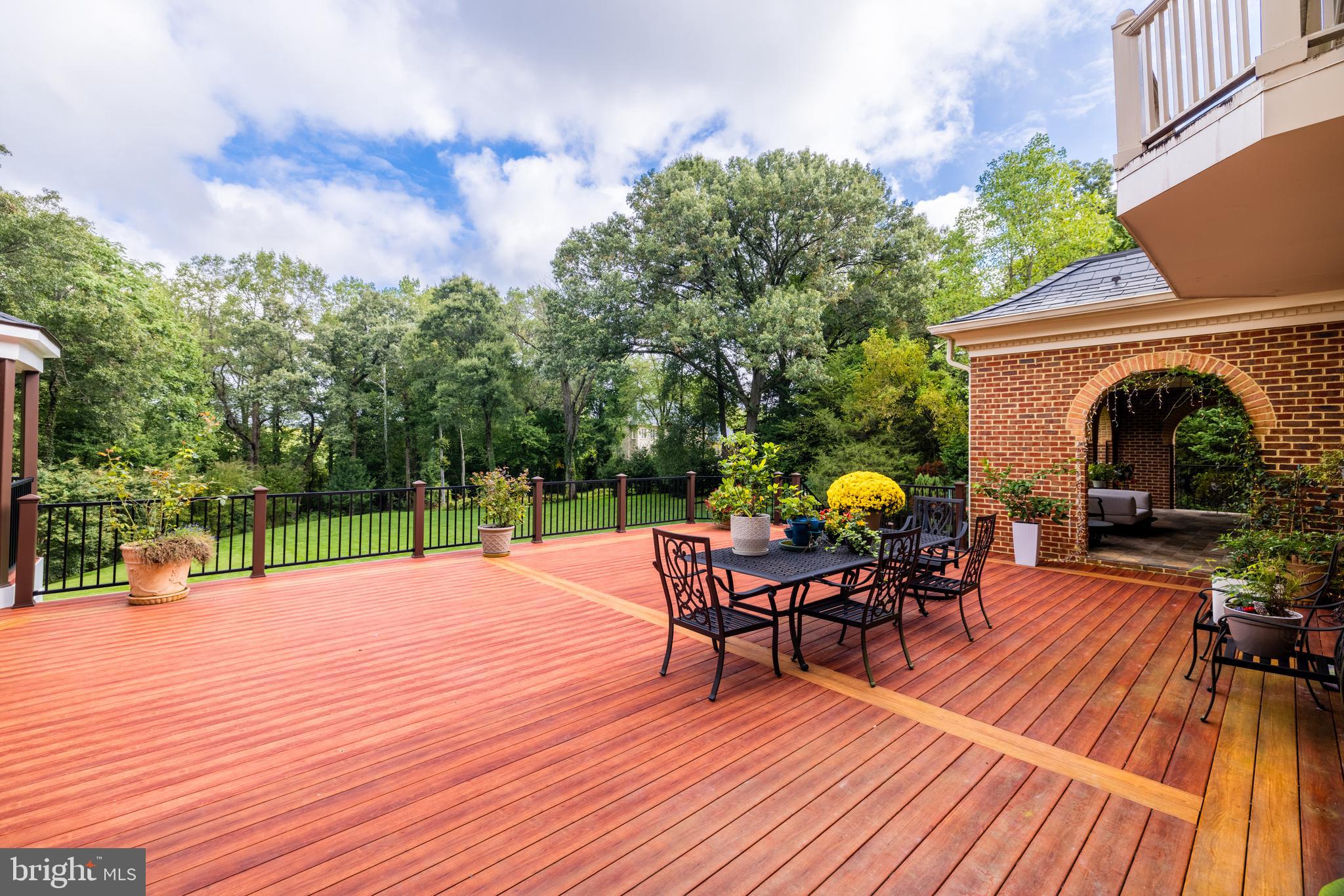 6832 Georgetown Pike McLean, VA 22101 - Photo 18 of 25 a patio with table and chairs and potted plants with wooden floor and fence