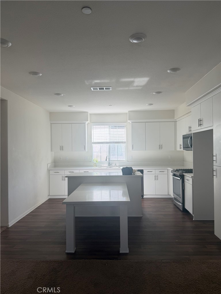 7357 Solstice Place Rancho Cucamonga, CA 91739 - Photo 5 of 12 a room with a table chairs microwave and view kitchen
