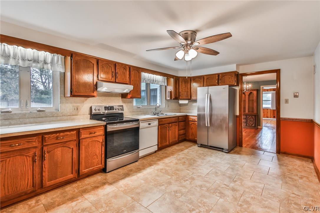 330 Wedgewood Road Bethlehem, PA 18017 - Photo 17 of 47 a kitchen with stainless steel appliances granite countertop a refrigerator a sink dishwasher a stove with wooden cabinets and floor