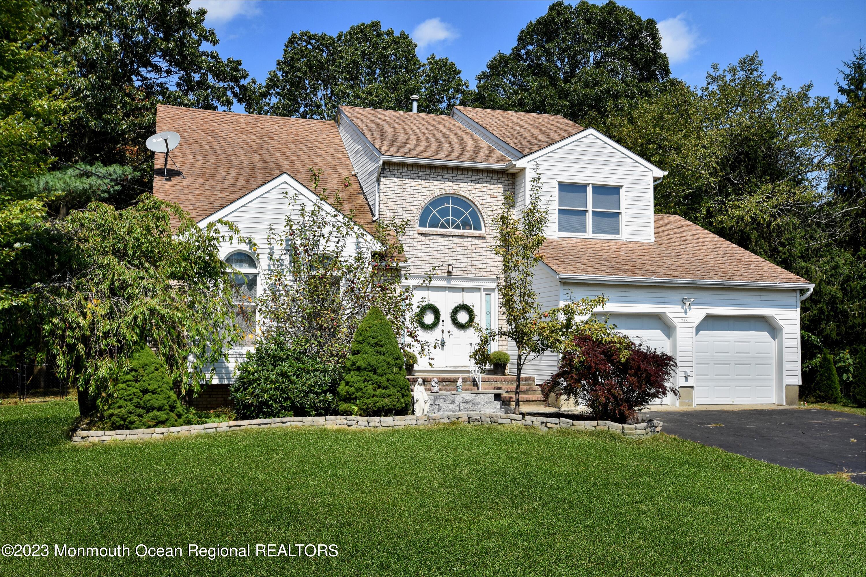 a front view of a house with a yard and green space