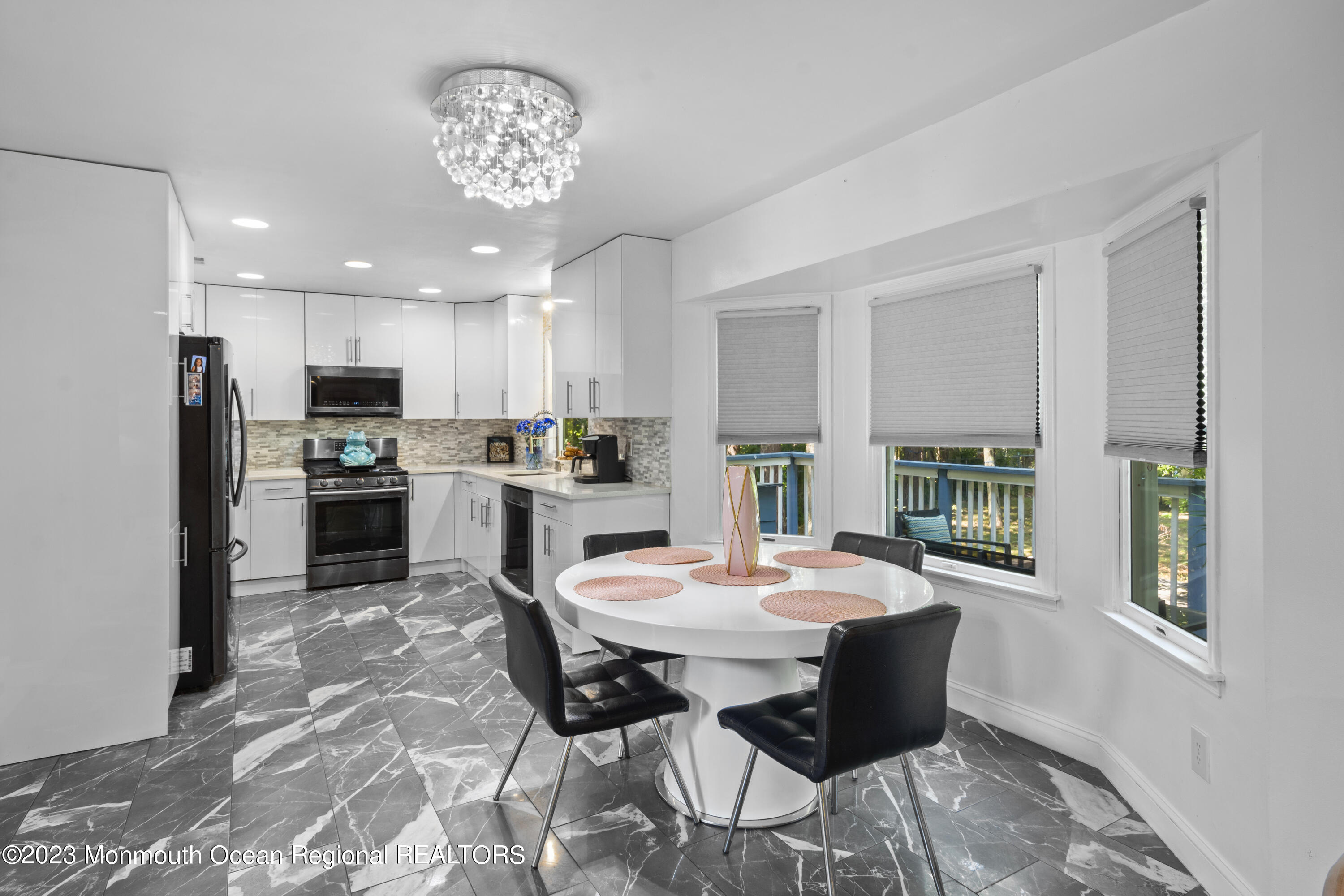 758 Anderson Road Jackson, NJ 08527 - Photo 12 of 35 a open dining room with stainless steel appliances kitchen island granite countertop a refrigerator a stove a microwave oven with a dining table and chairs