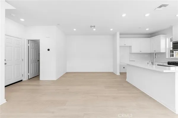 a view of kitchen with kitchen island a sink stainless steel appliances and cabinets