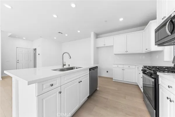 a kitchen with white cabinets appliances and sink